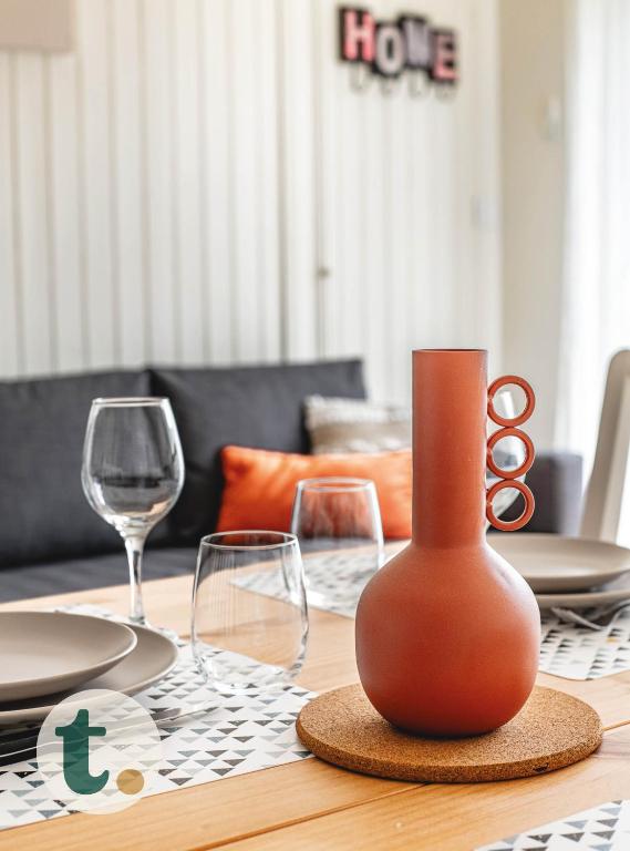 une table avec un vase sur une table avec des verres à vin dans l'établissement Tranquiloue - Chez nous - 8min du PuyduFou, à La Verrie