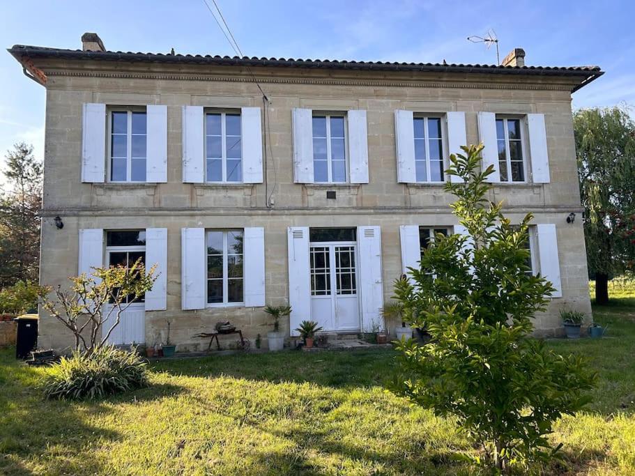 Cette maison ancienne dispose de fenêtres blanches et d'une cour. dans l'établissement Maison girondine près de saint emilion, à Saint-Magne-de-Castillon