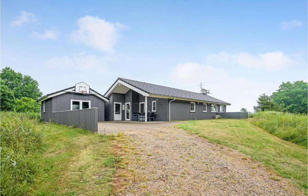 ein schwarzes Haus mit Kieseinfahrt in der Unterkunft Holiday Home Jtagholmsvej Rømø Denmark in Rømø Kirkeby
