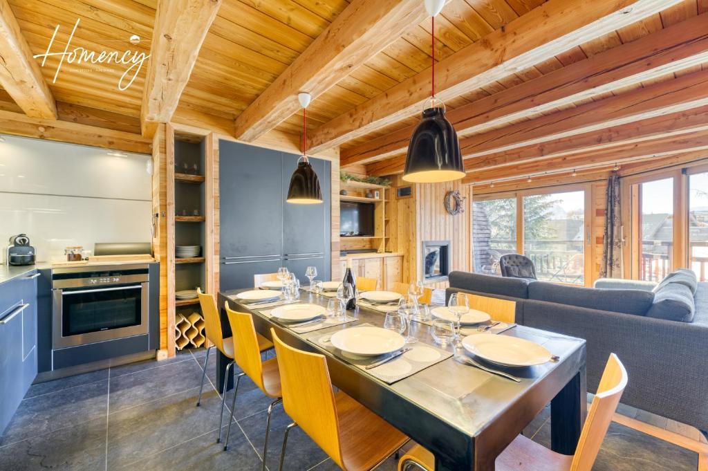 a dining room and kitchen with a table and chairs at Homency - Chalet Elussa in L'Alpe-d'Huez