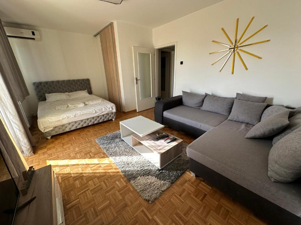 ein Wohnzimmer mit einer Couch und einem Bett in der Unterkunft Apartment 601 in Surčin