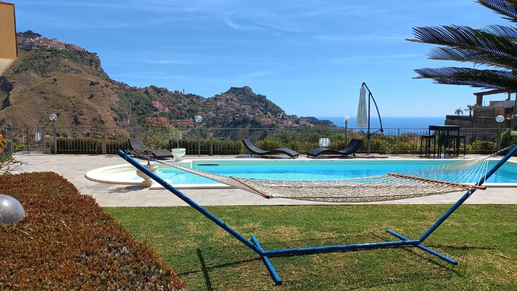 hamak w ogrodzie obok basenu w obiekcie Villa Victoria, Taormina w Taominie