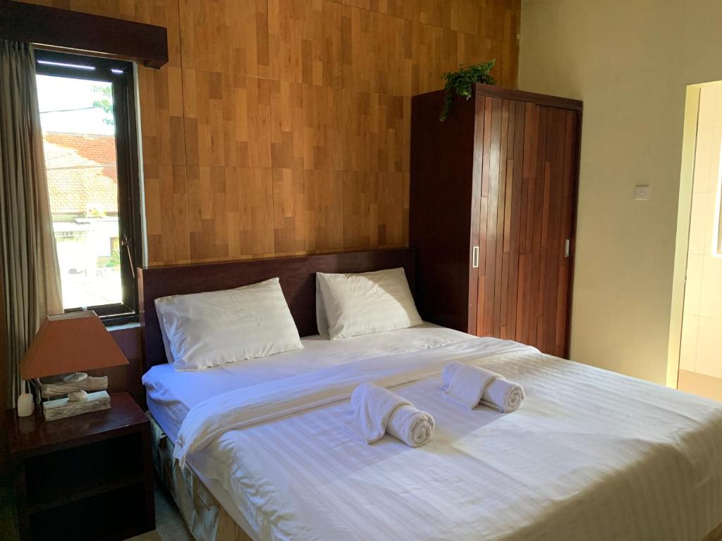 a bedroom with a bed with two towels on it at Cozy Palm Villa in Jimbaran