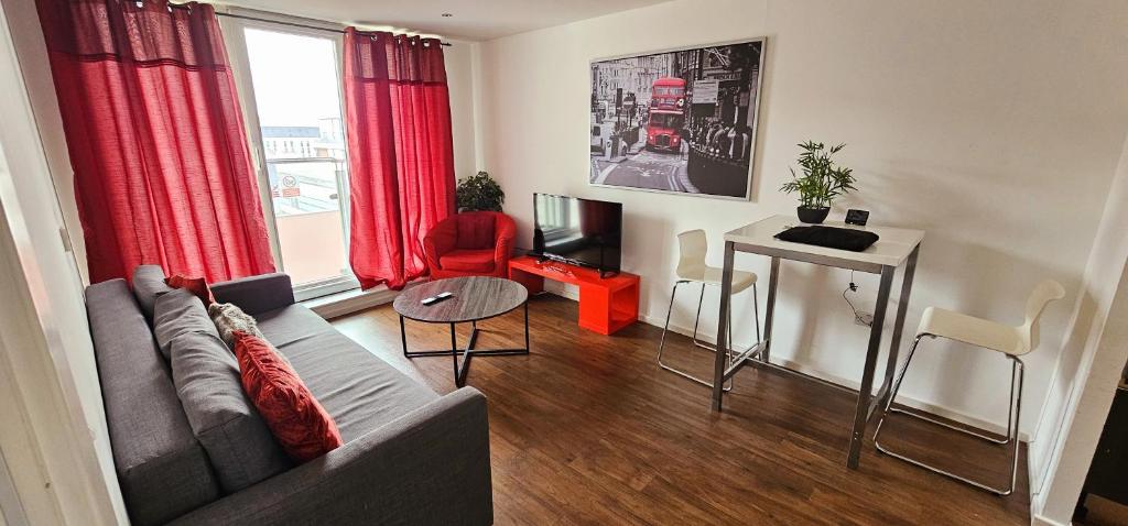 a living room with a couch and a table at Excel West Stays in London