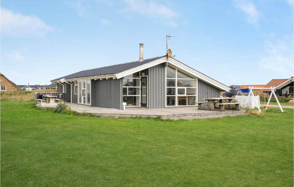 una casa gris con un gran césped delante de ella en Cozy Home In Harboøre With Sauna, en Harboør