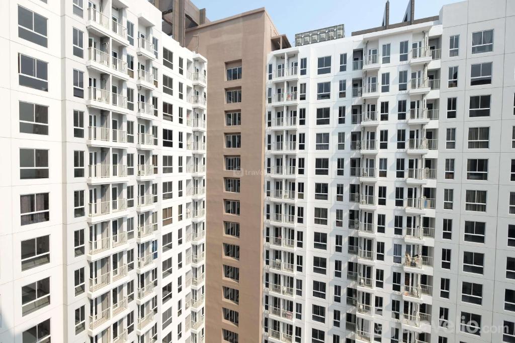 two tall white buildings standing next to each other at Comfort and Nice 2BR at Tokyo Riverside PIK 2 Apartment By Travelio in Rawalembang