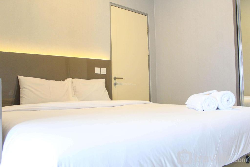 タンゲランにあるNew Furnished with City View 2BR Apartment M-Town Residence By Travelioのタオルが敷かれた大きな白いベッドのある寝室
