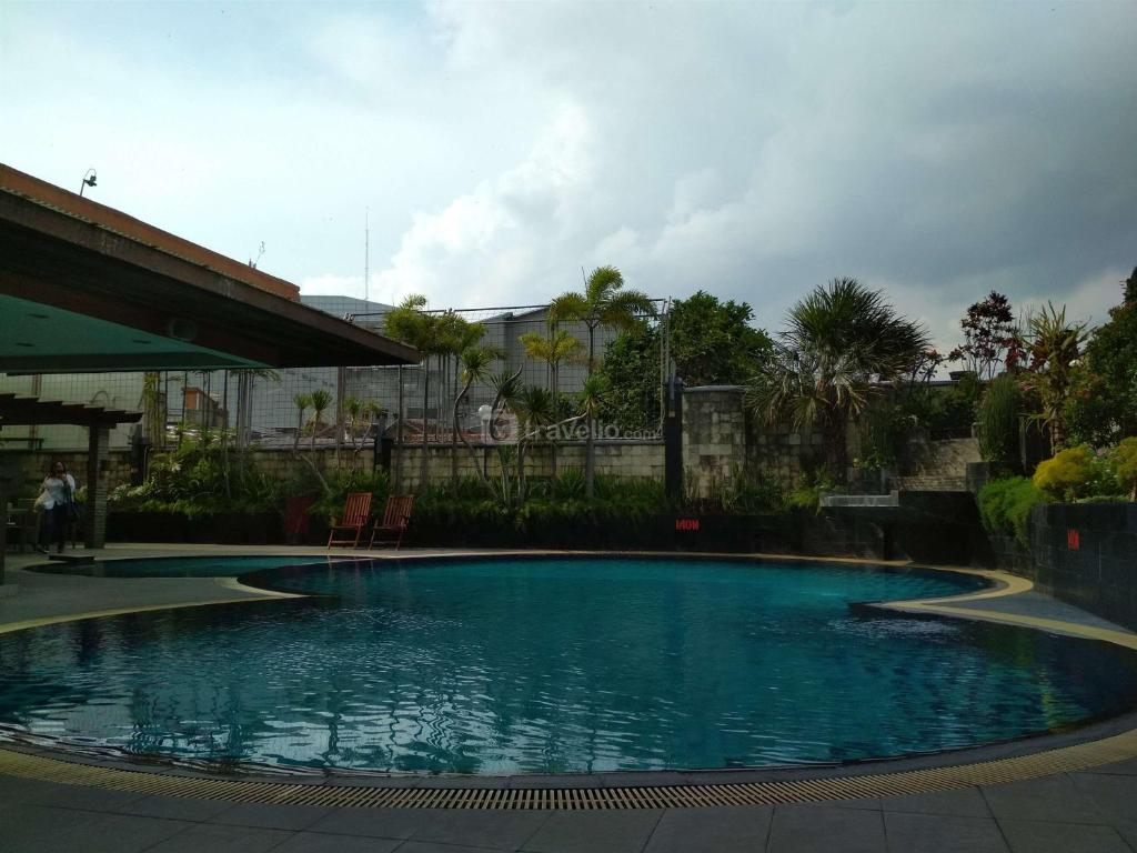 a large swimming pool with blue water at Scenic 2BR at Grand Setiabudi Apartment By Travelio in Bandung