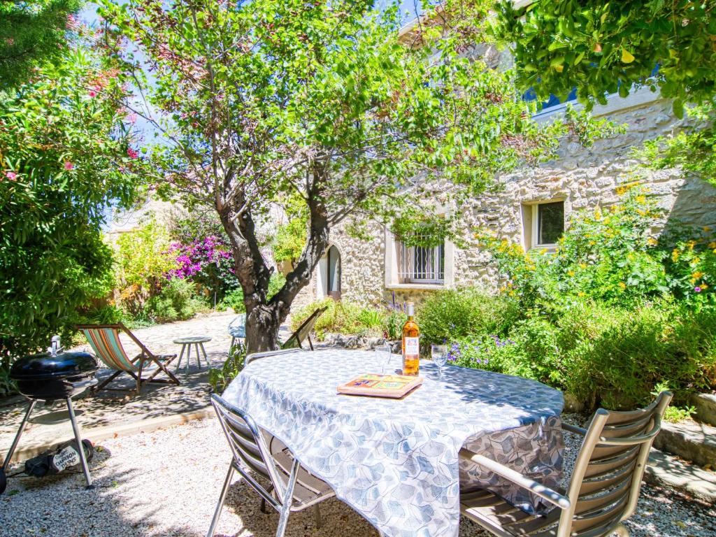 - une table avec une bouteille de vin dans le jardin dans l'établissement Apartment Mimosa by Interhome, à Six-Fours-les-Plages