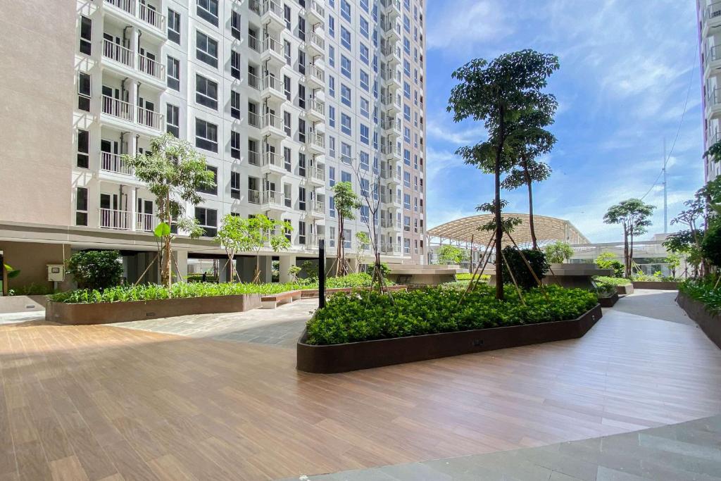 un patio en un edificio con un árbol. en Pleasurable and Tidy Studio at Tokyo Riverside PIK 2 Apartment By Travelio, en Rawalembang