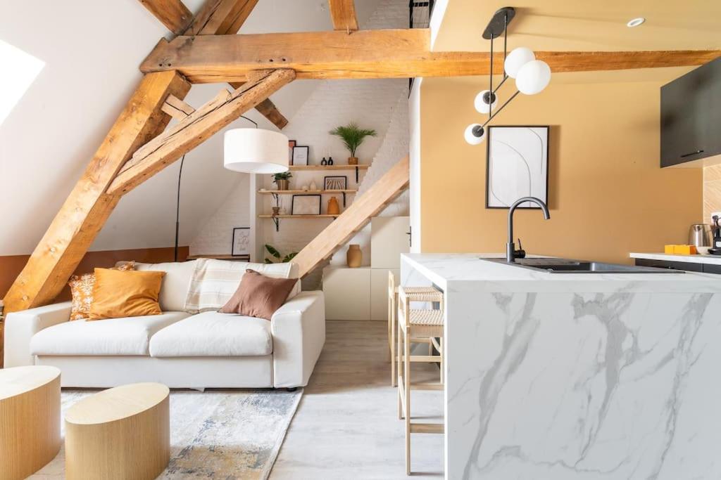 un salon avec un canapé blanc et une cuisine dans l'établissement Le cosy - Loft sublime Plein centre de Douai, à Douai