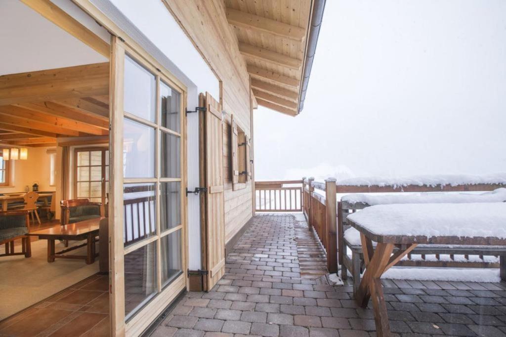 a balcony of a house with a bed and a table at Schöneben Chalet Waldkrone in Wald im Pinzgau