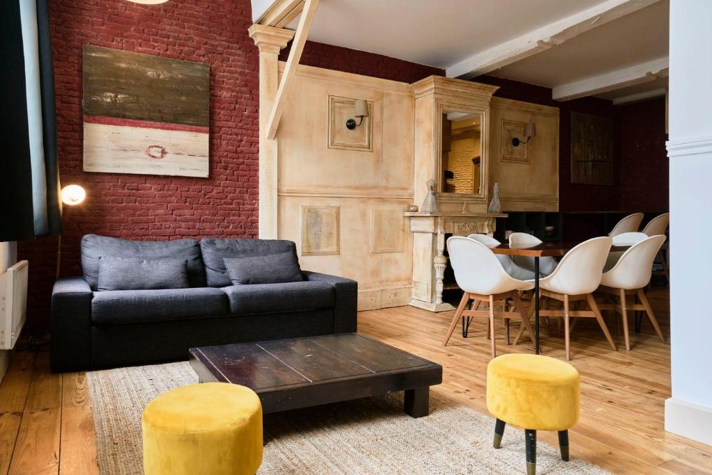 a living room with a couch and a table and chairs at Old Lille charming duplex apartment in Lille