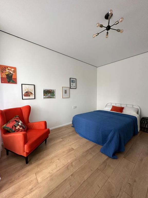 a bedroom with a bed and a red chair at Cozy Urban Retreat in Prigorodnyy