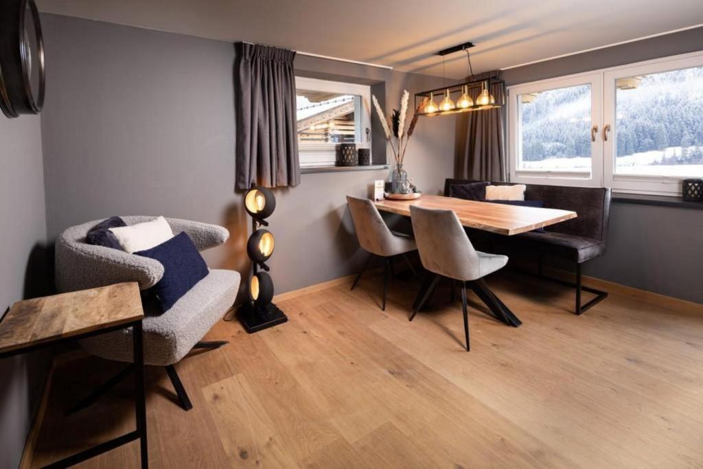 un salon avec une table et des chaises de salle à manger dans l'établissement Schöneben Appartementen Top 1, à Wald im Pinzgau