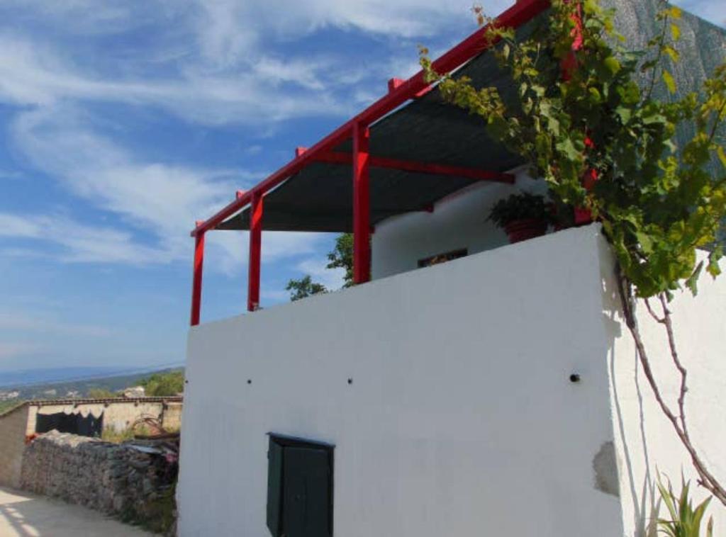 a white building with a red roof on top of it at Apartment Dario Šolta in Grohote