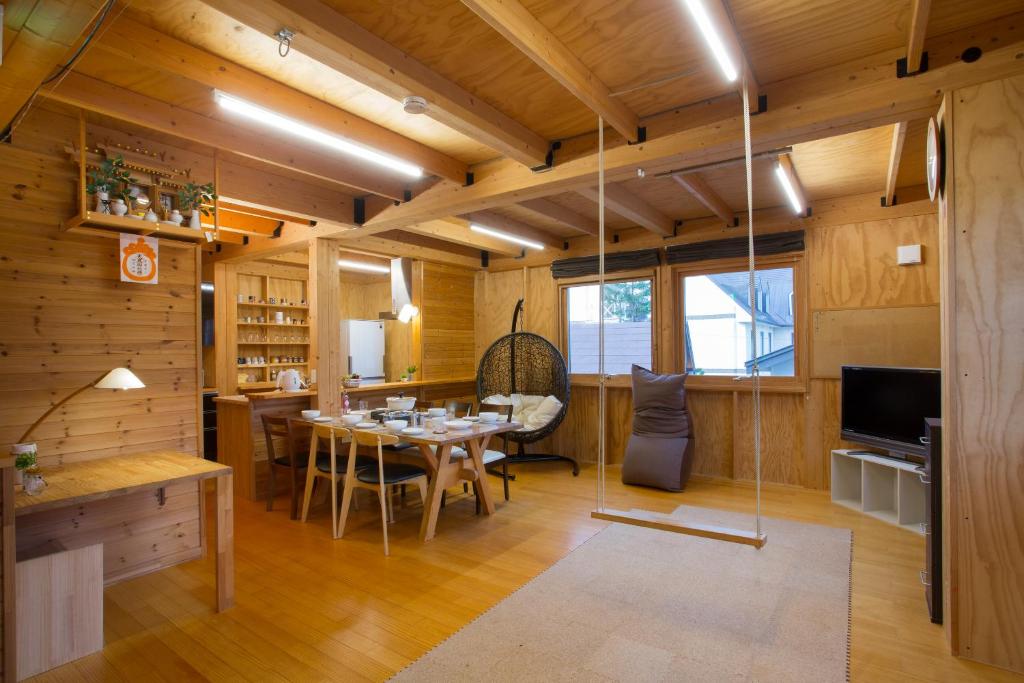 a dining room with a table and chairs and a television at BRICK HOUSEⅡ in Furano