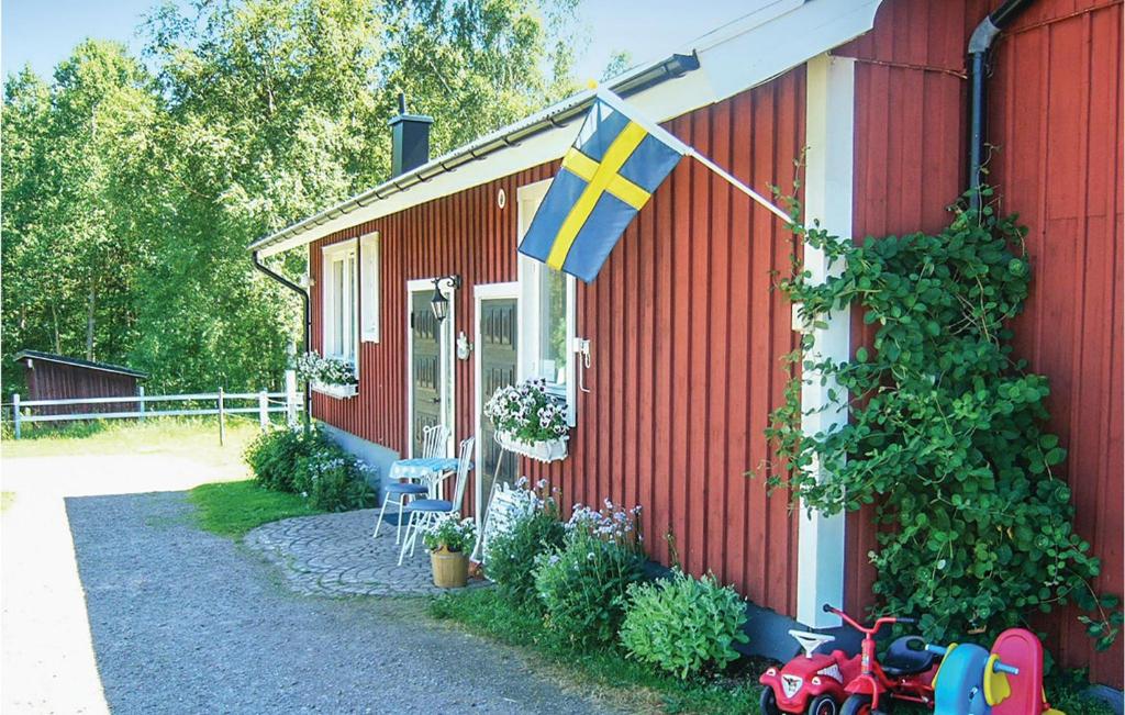 ビンメルビューにあるTwo-Bedroom Holiday Home In Vimmerbyの赤い家の側面に旗が掲げられている