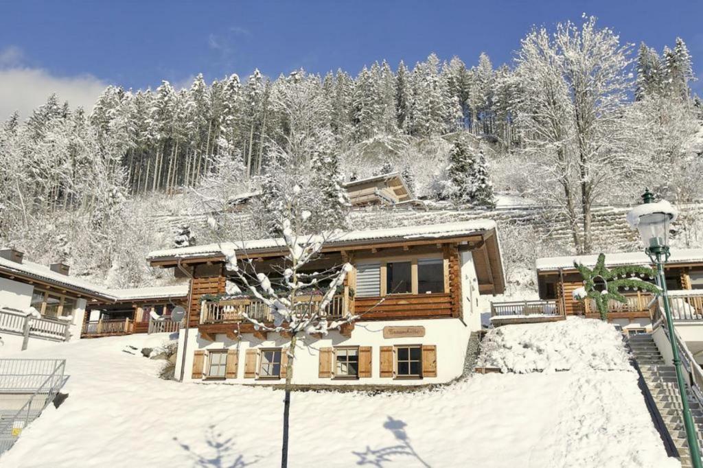 une cabane en rondins dans la neige avec des arbres enneigés dans l'établissement Schöneben Traumhütte, à Wald im Pinzgau