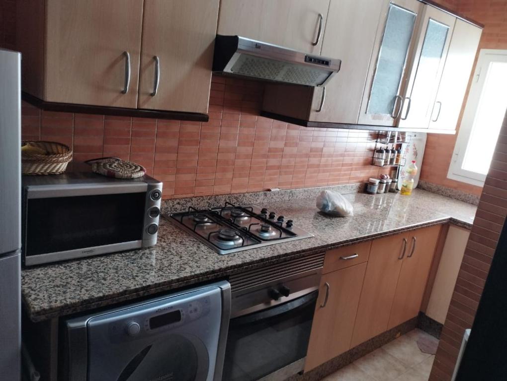 una cocina con estufa y microondas en Cosy appartement Front de mer - Marina Studio, en Marina Smir