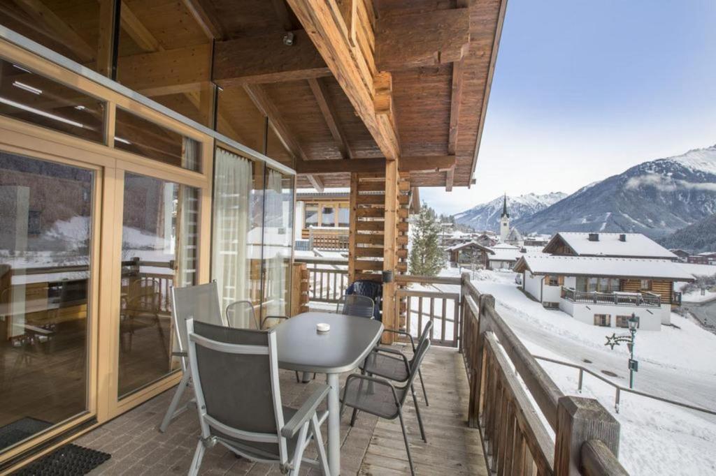 une chambre avec un balcon avec une table et des chaises dans l'établissement Schöneben Chalet Enzian, à Wald im Pinzgau