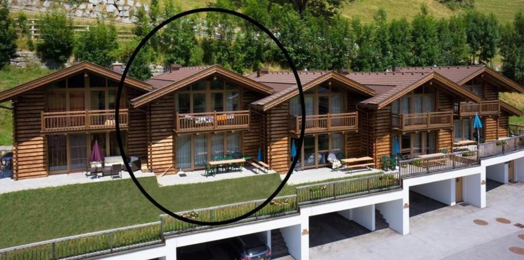 une grande maison en rondins avec une cour dans l'établissement Schöneben Haus Silberdistel, à Wald im Pinzgau