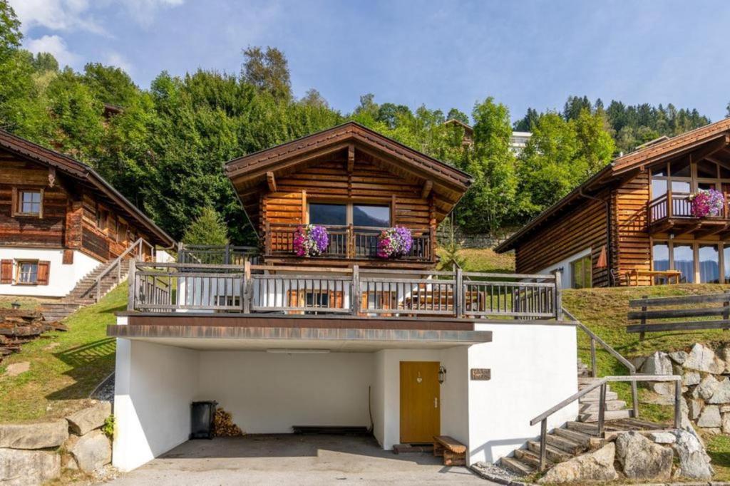 ein Haus mit einem Balkon mit Blumen darauf in der Unterkunft Schöneben Chalet Edelhirsch in Wald im Pinzgau
