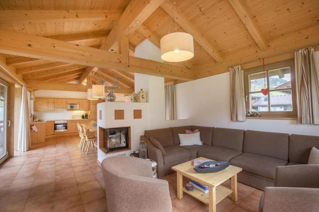 a living room with a couch and a fireplace at Schöneben Zwillinger Hütte in Wald im Pinzgau