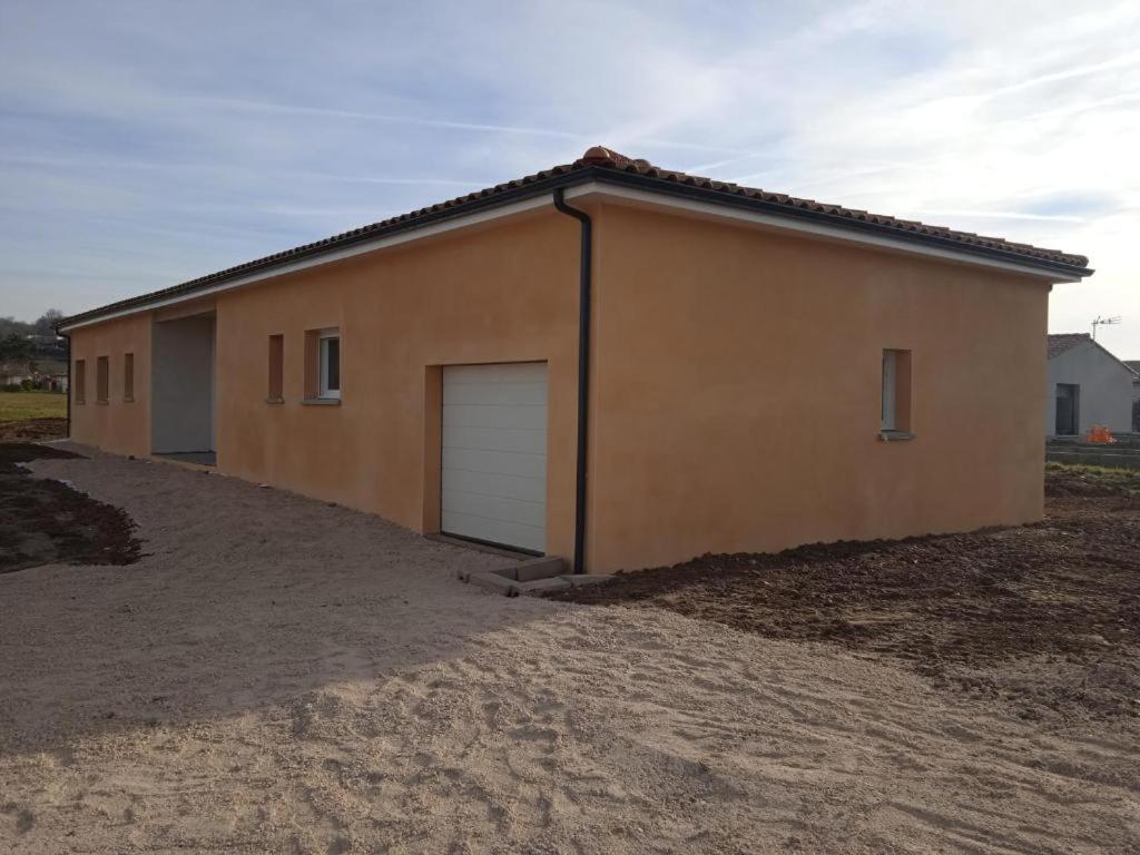 a large building with a garage in a field at La villa des Mûriers très spacieuse de 1 à 8 voyageurs avec lit bb dans un environnement calme dans les coteaux in Malause