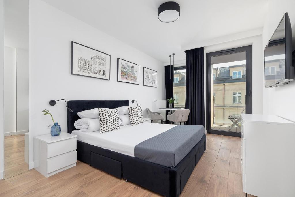 a bedroom with a large bed and a table at Selenite - Studio with Balcony & AC - City Center in Krakow