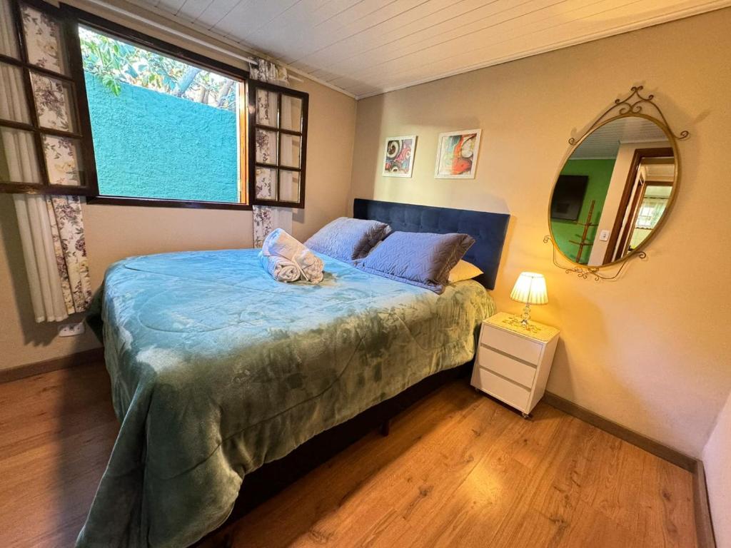 a bedroom with a bed and a large window at Chalé Completo 5min centrinho in Campos do Jordão