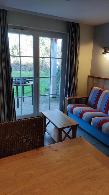 un salon avec un canapé et une table dans l'établissement Argousiers 24, à Fort-Mahon-Plage