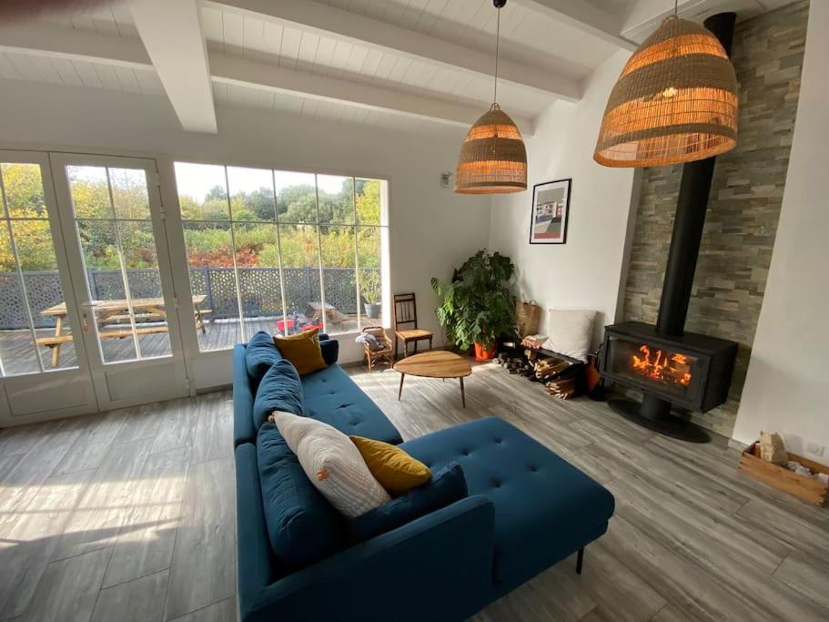 a living room with a blue couch and a fireplace at Maison 10 lits proximité du Port - YEU Ker Chalon in Port-Joinville