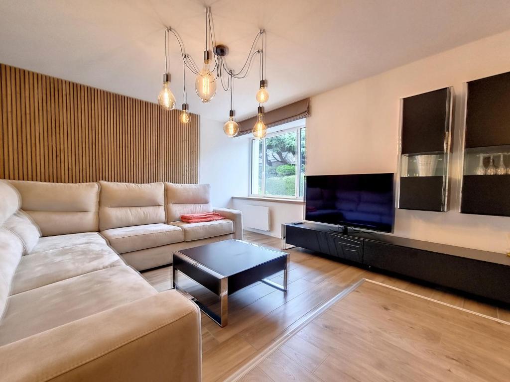 un salon avec un canapé et une télévision dans l'établissement Mont Gîte Des Herbus Salicorne 6personnes entre Granville et Mont Saint Michel, à Vains