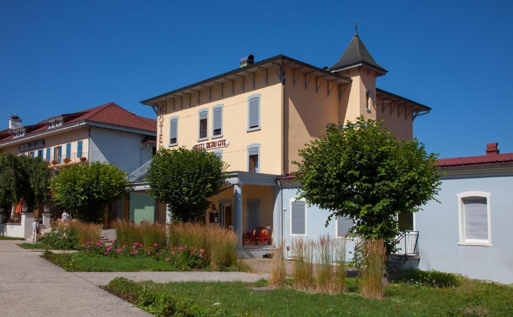 una casa grande con una torreta en una calle en Hôtel Beau Site en Malbuisson