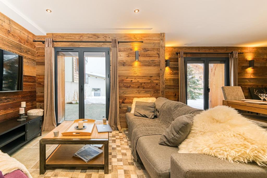 salon z kanapą i stołem w obiekcie Homency - Chalet La Biche w LʼAlpe-dʼHuez