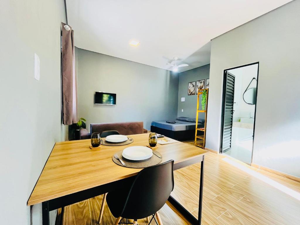 Un comedor con mesa y sillas de madera. en Studio 209-AP1- espaço completo ideal para casal, en Ubatuba