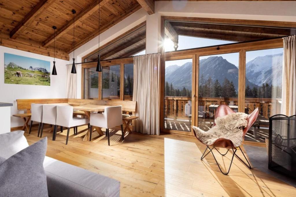 a dining room with a table and views of mountains at Nationalpark Chalet Blindis in Neukirchen am Großvenediger