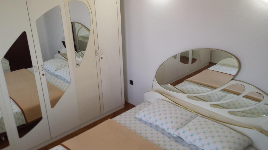 a small room with two mirrors and a bed at Apartment Golubica 2 in Marina