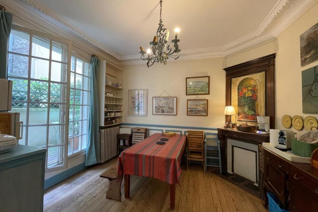 d'une salle à manger avec une table et quelques fenêtres. dans l'établissement Spacious house a few steps from the sea, à Trouville-sur-Mer