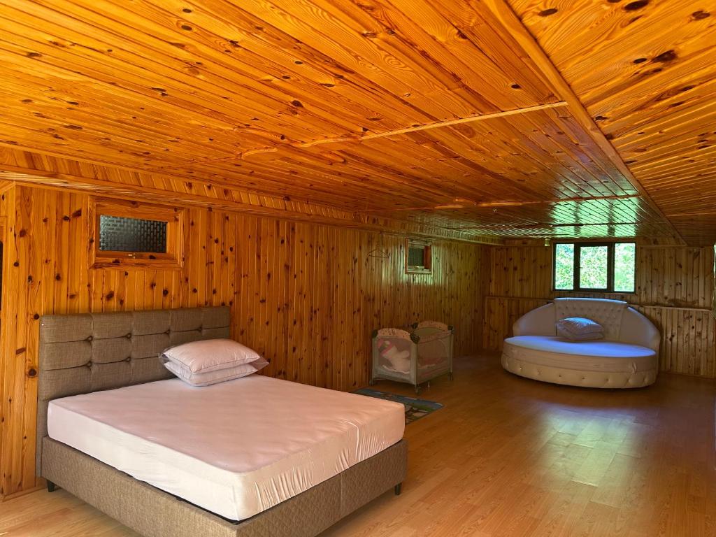 a bedroom with a bed and a tub in a room at Holiday house in nature in Keda