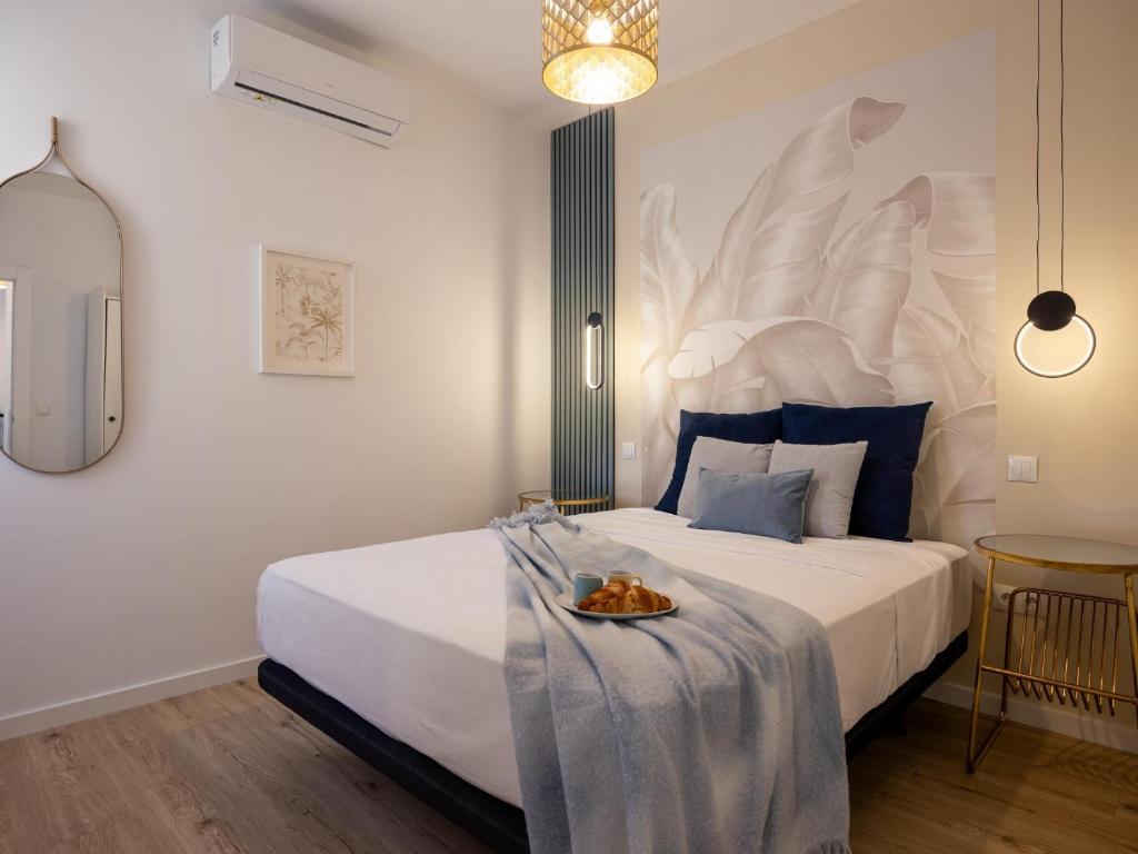 a bedroom with a large bed with a plate of food on it at Torremolinos Centro Apartamento con parking y playa a 5 min, wifi alta velocidad in Torremolinos