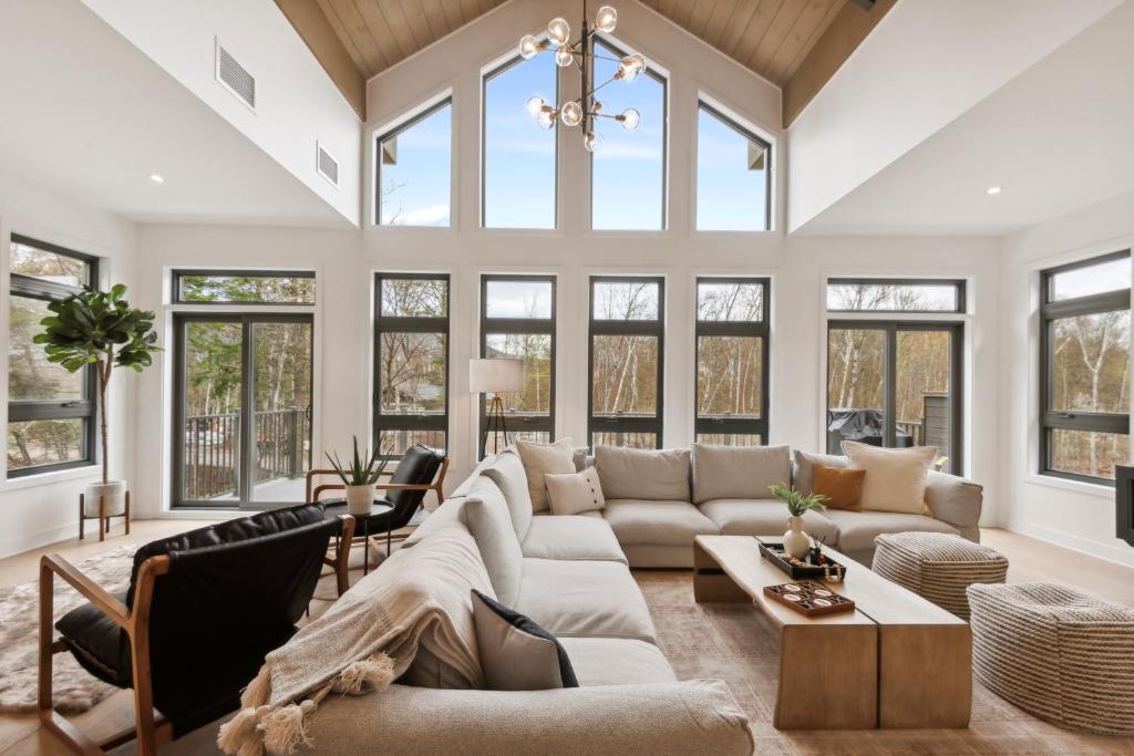 a living room with a large couch and windows at Tremblant Prestige - Verbier 12-203 in Mont-Tremblant