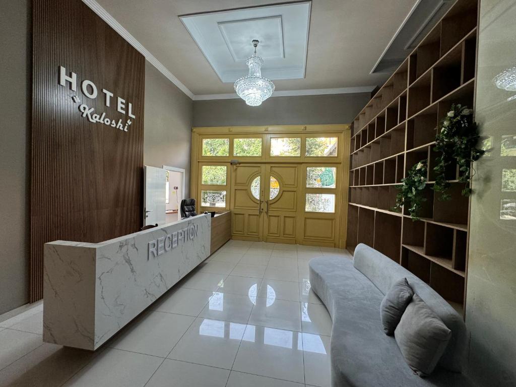 Un vestíbulo de hotel con un sofá frente a una puerta. en Hotel Kaloshi, en Tirana