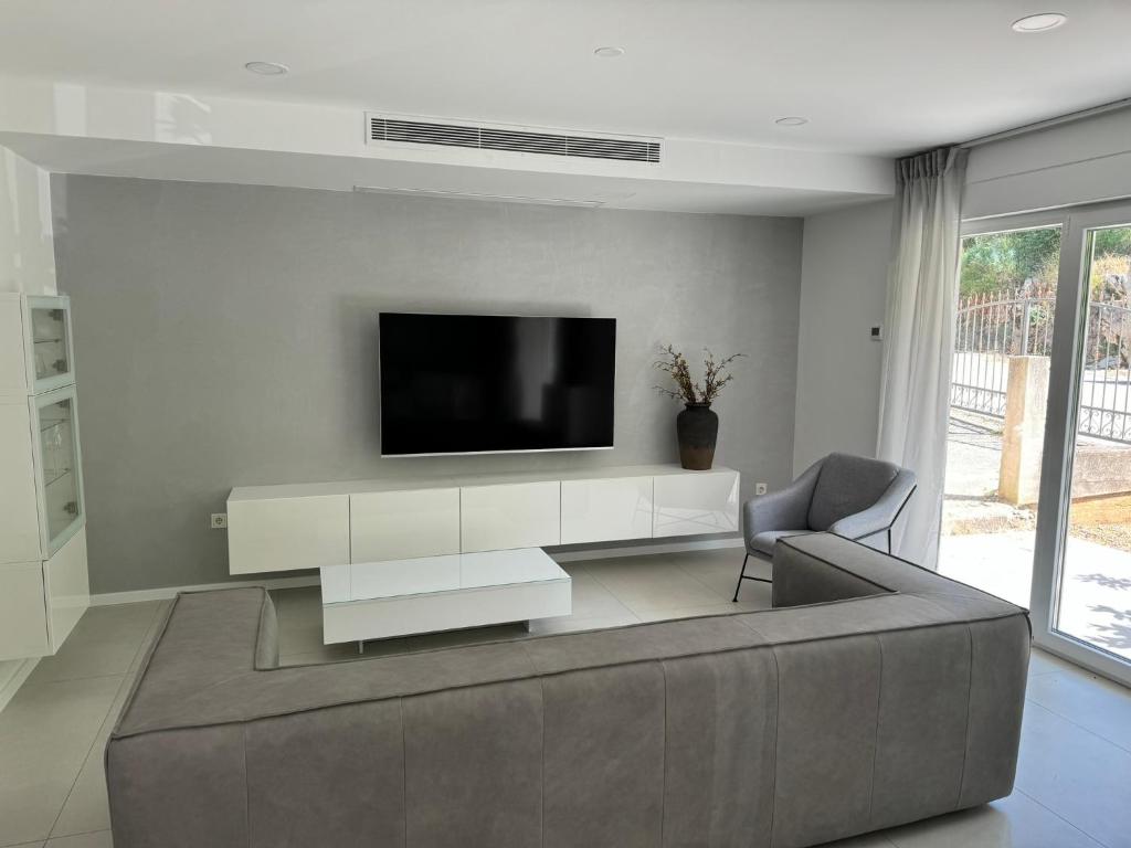 a living room with a couch and a tv on a wall at FRANE-APART - Čiovo in Trogir