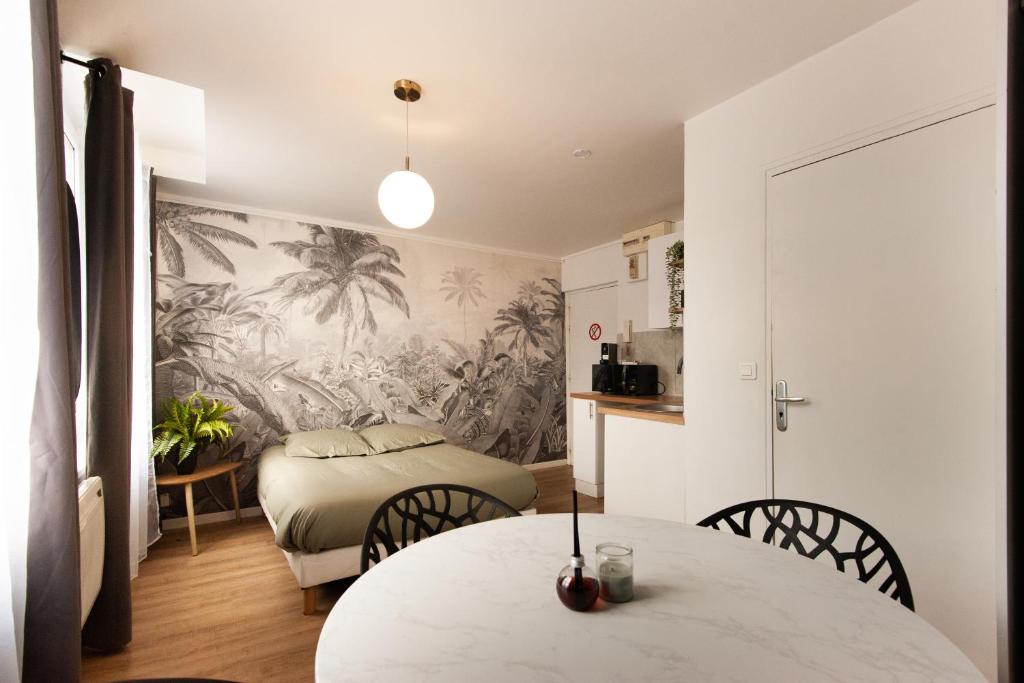 une pièce avec une table et des chaises et une chambre dans l'établissement L'escapade studio en Hypercentre Cathédrale, à Amiens