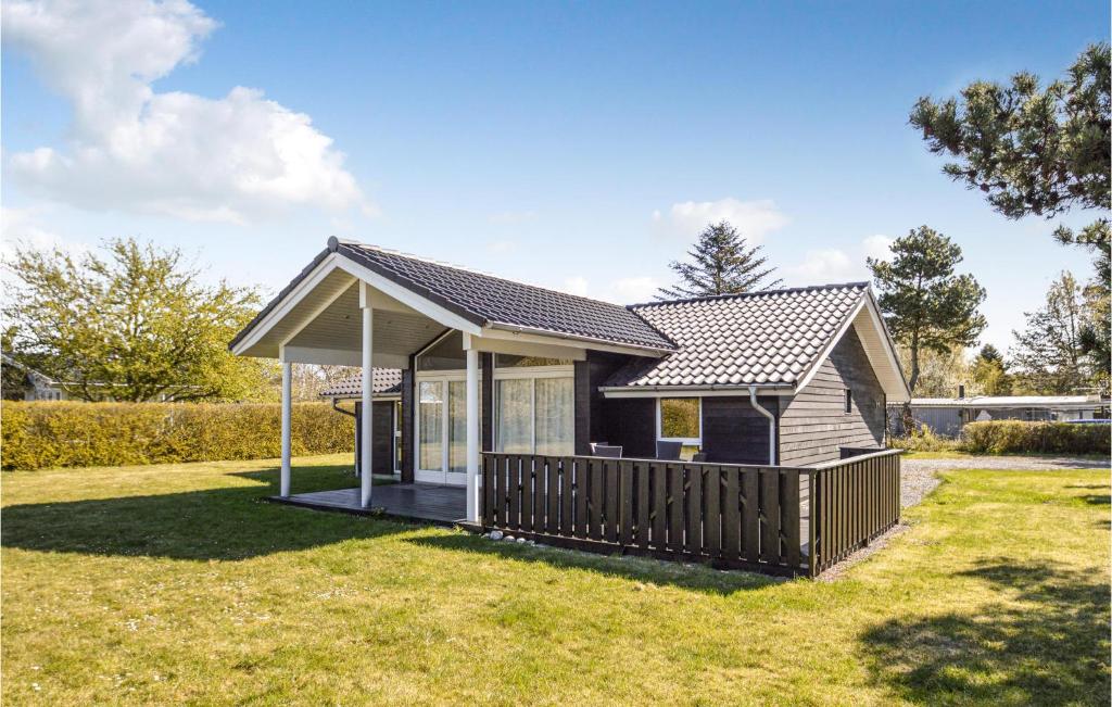 a small house with a deck in a yard at 3 Bedroom Amazing Home In Nakskov in Knubbeløkke