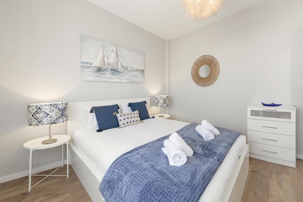 a bedroom with a bed with a blue blanket at Consolação Beach Villa in Atouguia da Baleia