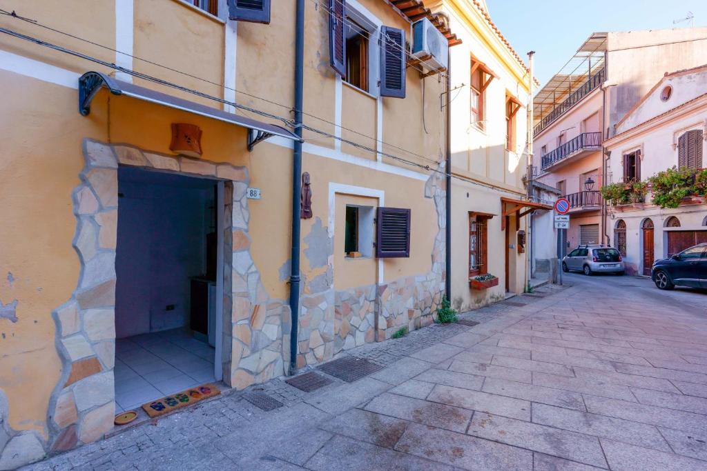 a building with a garage on the side of a street at Naos Casa Vacanze in Iglesias