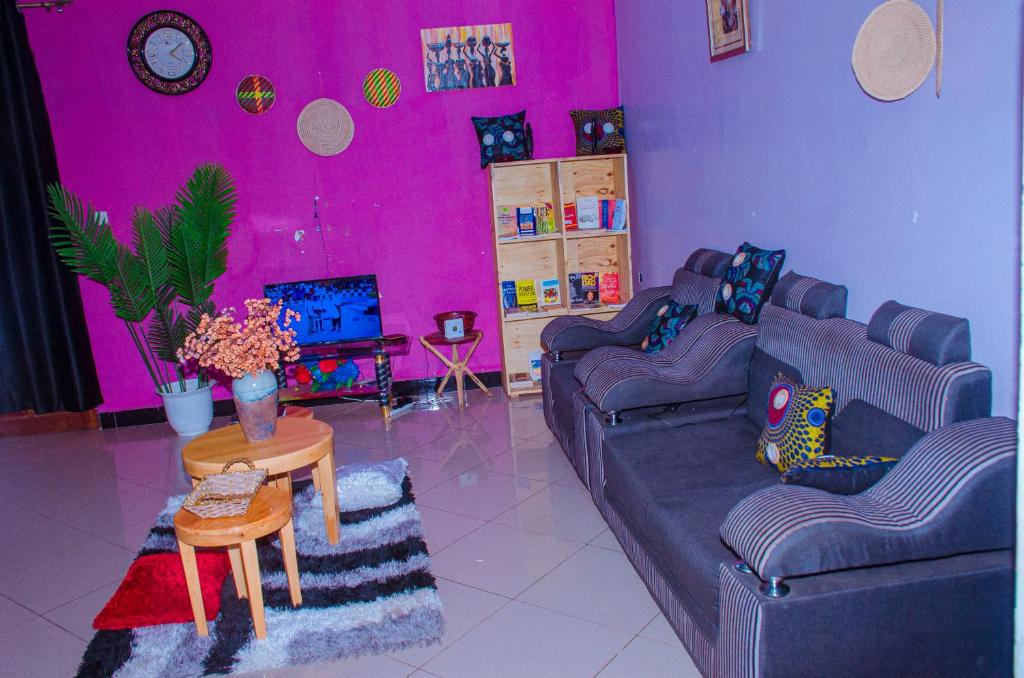 a purple living room with two couches and a table at Tarangwe Homestay & Hostels in Iringa
